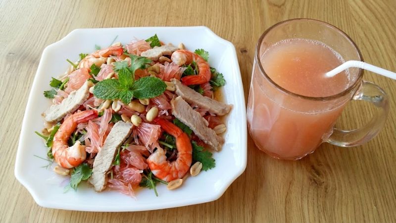 Dĩa gỏi bưởi tôm thịt bắt mắt cạnh ly nước ép bưởi da xanh